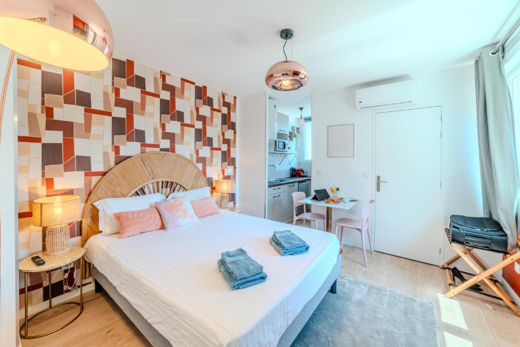 a bedroom with a bed with two towels on it at Tulipe Roanne centre-ville - Parking & Clim in Roanne