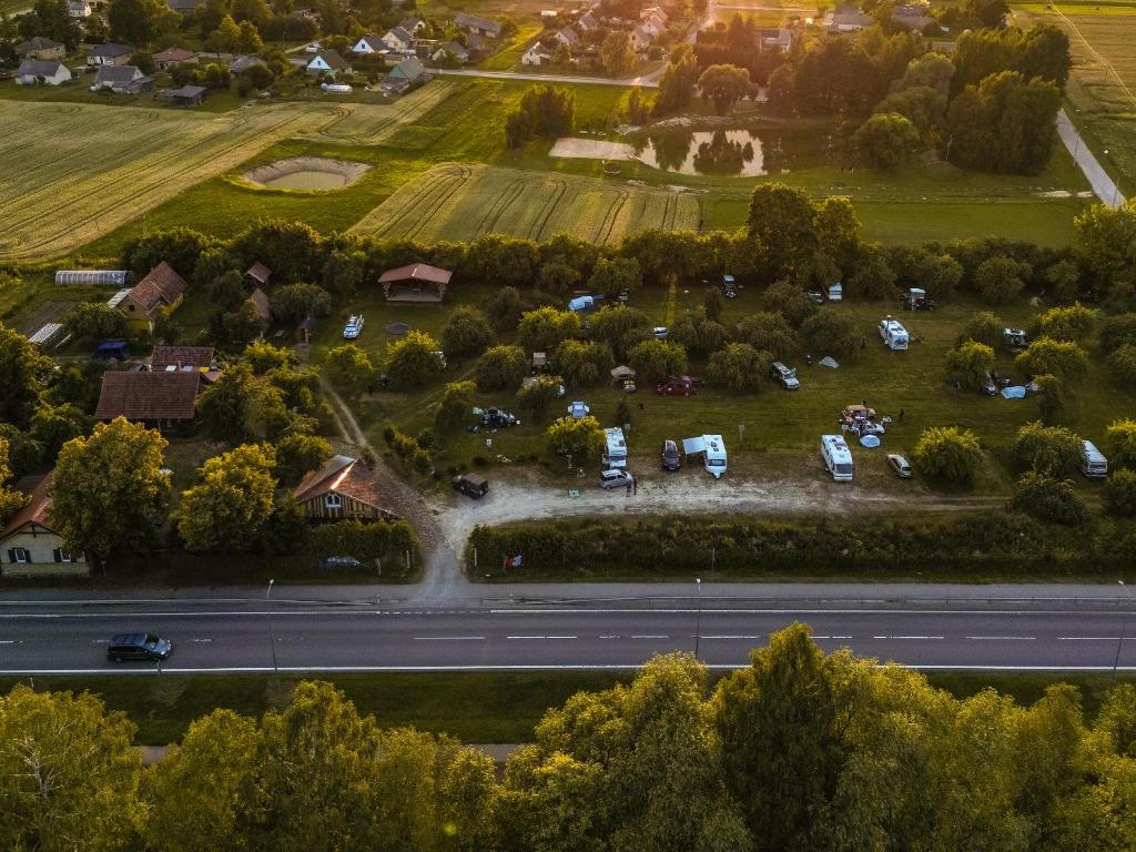 an overhead view of a road with cars parked in a field at Sunny Nights Homestead Rustic House in Gataučiai