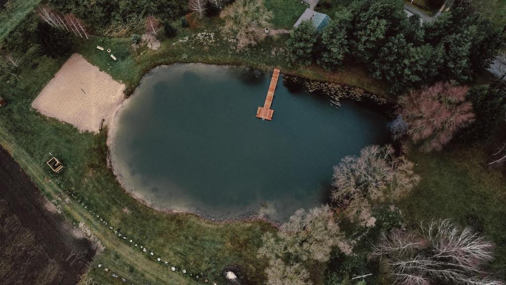 an overhead view of a large lake in a field at Sunny Nights Homestead Rustic House in Gataučiai