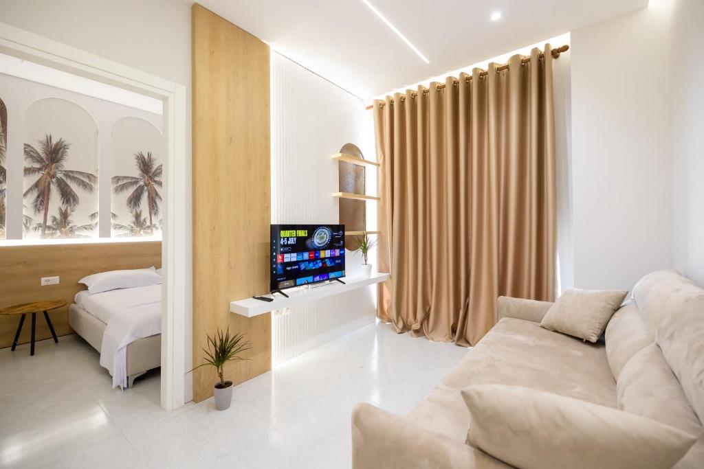 a white living room with a couch and a bed at Nova Studio Drymades in Dhërmi