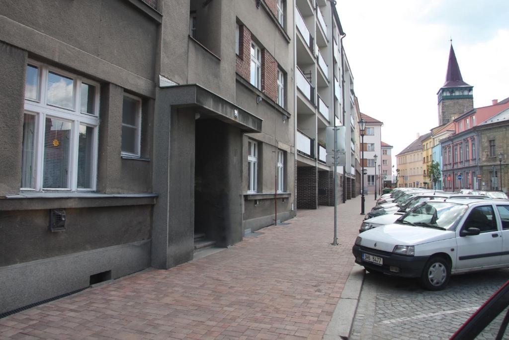 ein weißes Auto, das auf einer Straße neben Gebäuden parkt in der Unterkunft Apartmán U krále Tylova 515 in Jičín