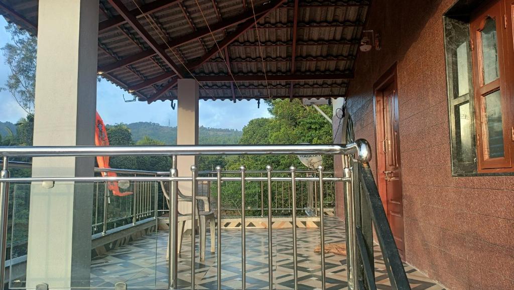 a balcony with a gate and a view of a yard at Saketa Homestay in Linganamakki