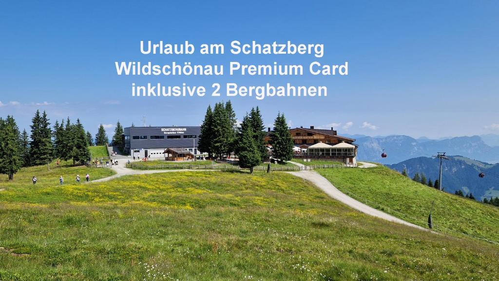 un edificio su una collina erbosa con una strada di Berggasthof Schatzbergalm a Thierbach