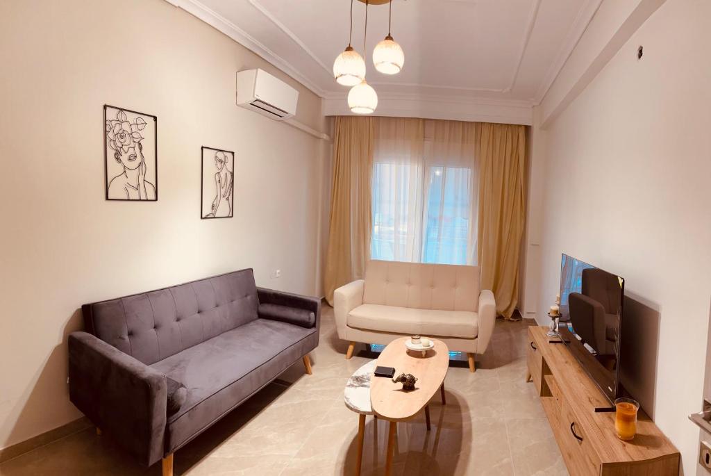 a living room with a couch and a tv at Blue two apartment in Kavála