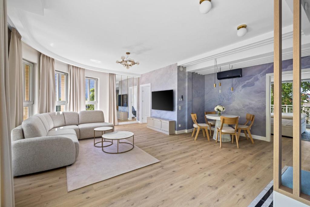 ソポトにあるWilla Na Wydmach Sopot by OneApartmentsのソファとテーブルのあるリビングルーム