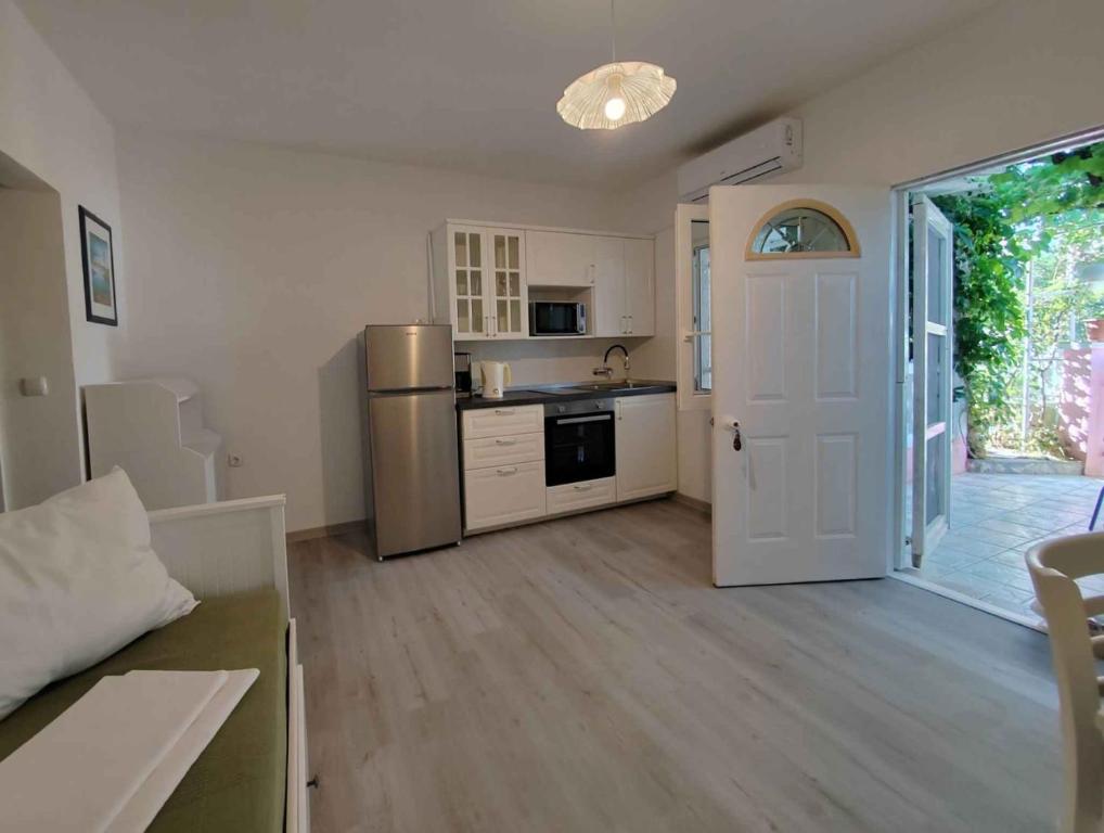 a kitchen with a refrigerator and a table and a door at Apartment Povljana 1 in Povljana