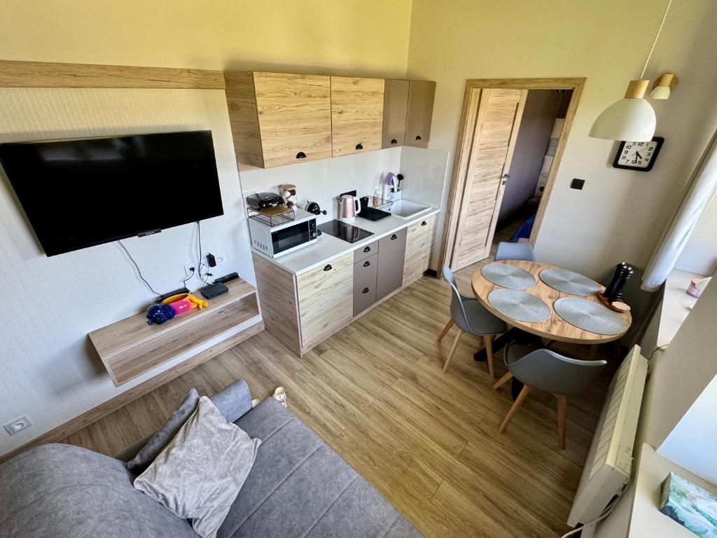 a small living room with a table and a kitchen at Błękitne Wierchy in Murzasichle