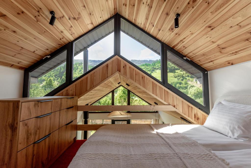 スラブスクにあるUGRAD family котедж з чаном-джакузіのツリーハウス内のベッドルーム(大きな窓付)