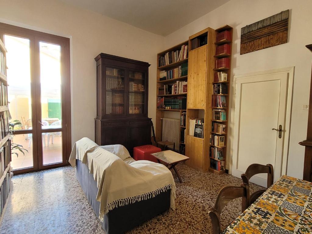 a living room with a bed and a book shelf at Ampia camera vicina al centro in Florence