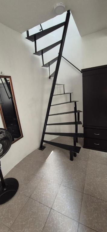 a staircase in a room with a mirror and a chair at Deptos Lago de Guadalupe in Mexico City