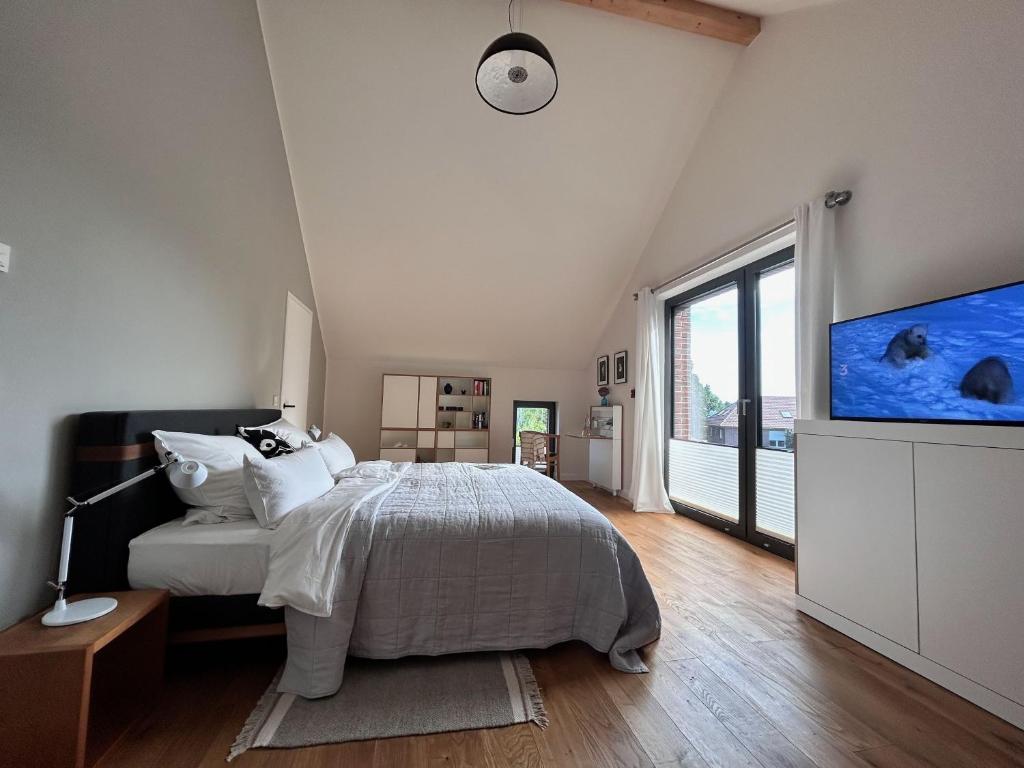 a bedroom with a bed and a flat screen tv at Wattkante B&B in Burhave