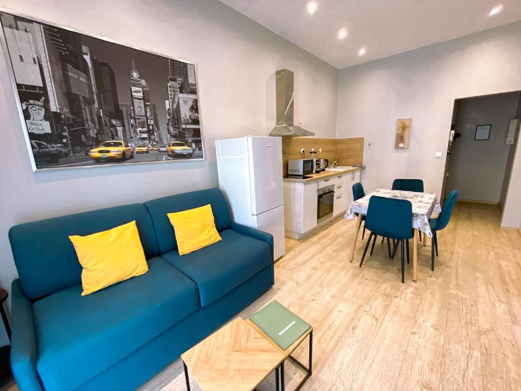 un salon avec un canapé bleu et une table dans l'établissement Confort & clim Logement 4 pers proche gare, centre et Polygone, à Béziers