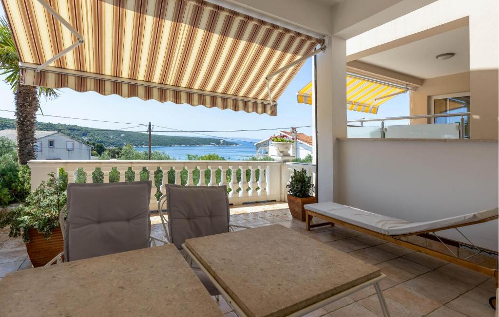 a patio with a table and chairs and a balcony at 1 Bedroom Awesome Apartment In Kampor in Kampor