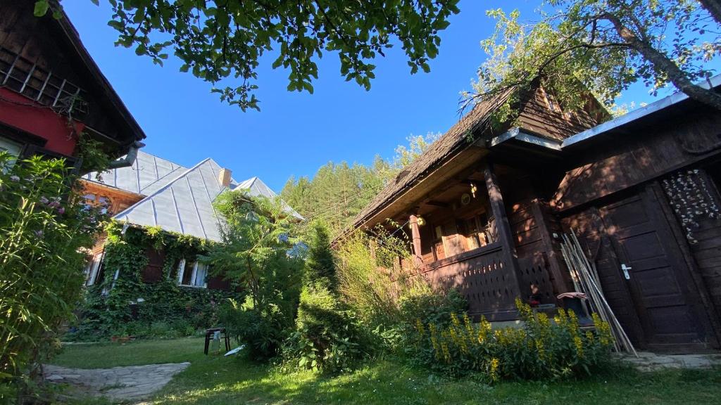 an old house with a grassy yard in front of it at Woodenhouse Maramures in Vişeu de Sus