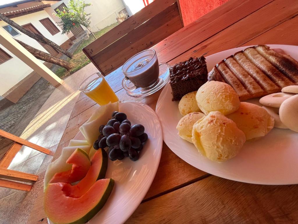 a wooden table with two plates of food on it at Pousada Cipó in Serra do Cipo