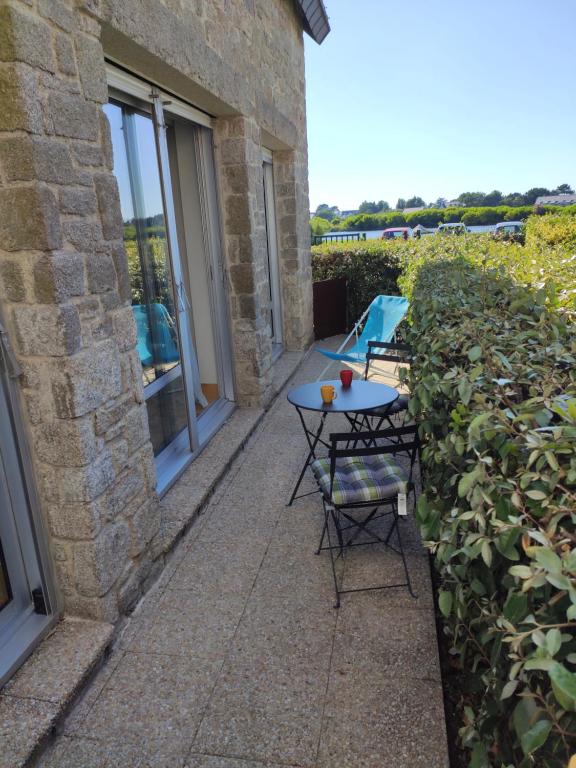 a patio with a table and chairs next to a building at Appartement Salines 46m2 in Carnac