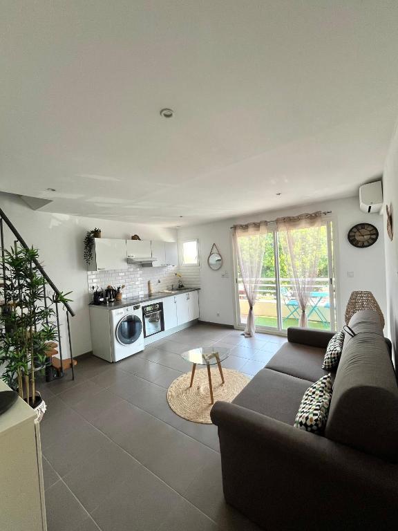 un salon avec un canapé et une cuisine dans l'établissement Bobo chic paradise, à Villeneuve-Loubet