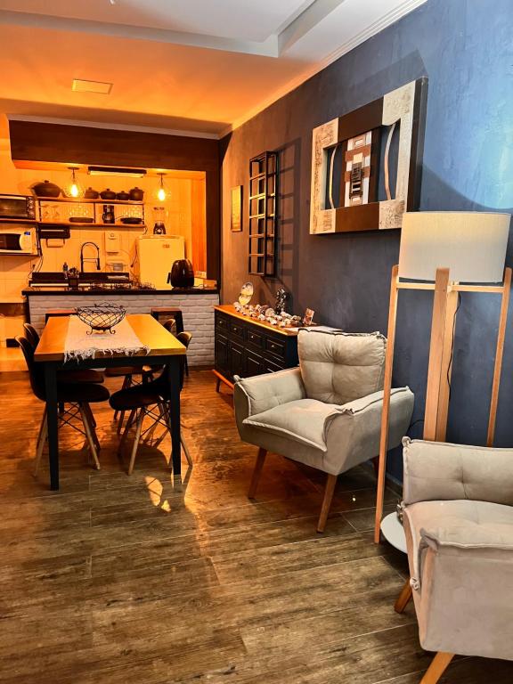 ein Wohnzimmer mit Tisch und Stühlen und eine Küche in der Unterkunft A casa azul in Paraty