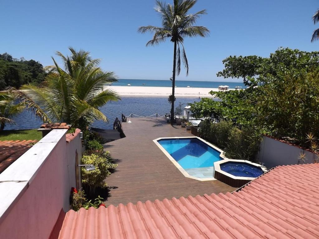 eine Terrasse mit Pool neben dem Strand in der Unterkunft Casa na Barra do Una, à beira do Rio Una e frente a Praia in São Sebastião