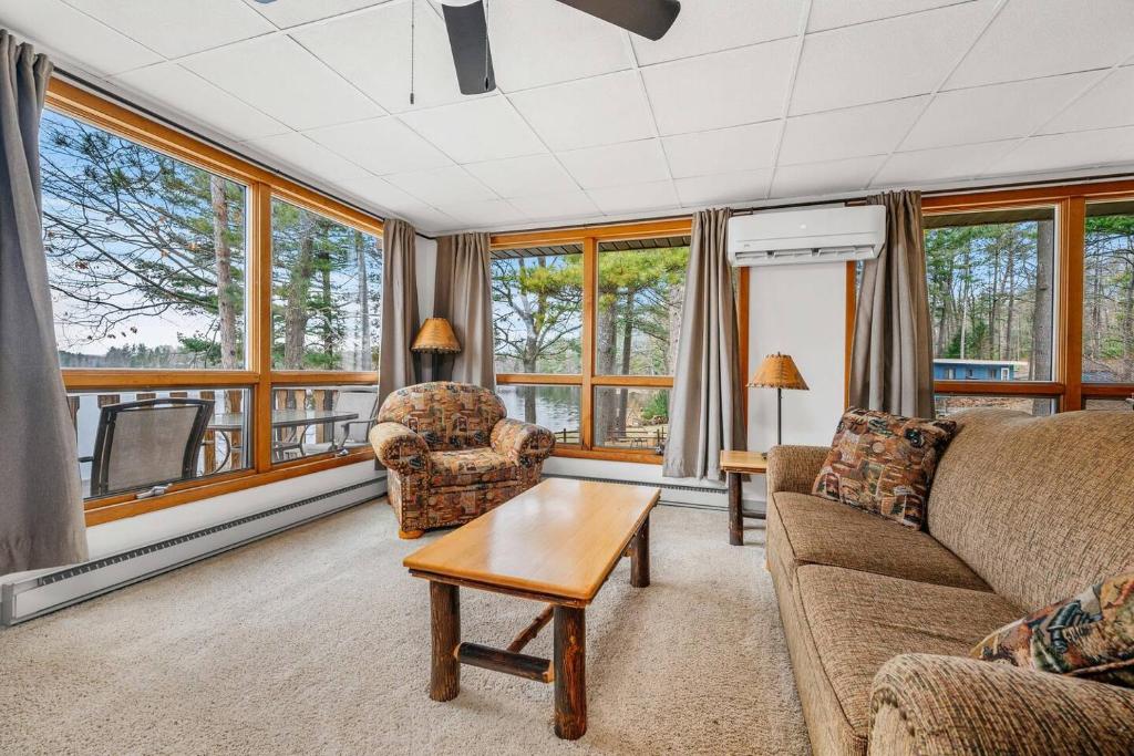 a living room with a couch and chairs and windows at Fishing-Spider Lake-Pontoon Rental-Family Friendly in Traverse City