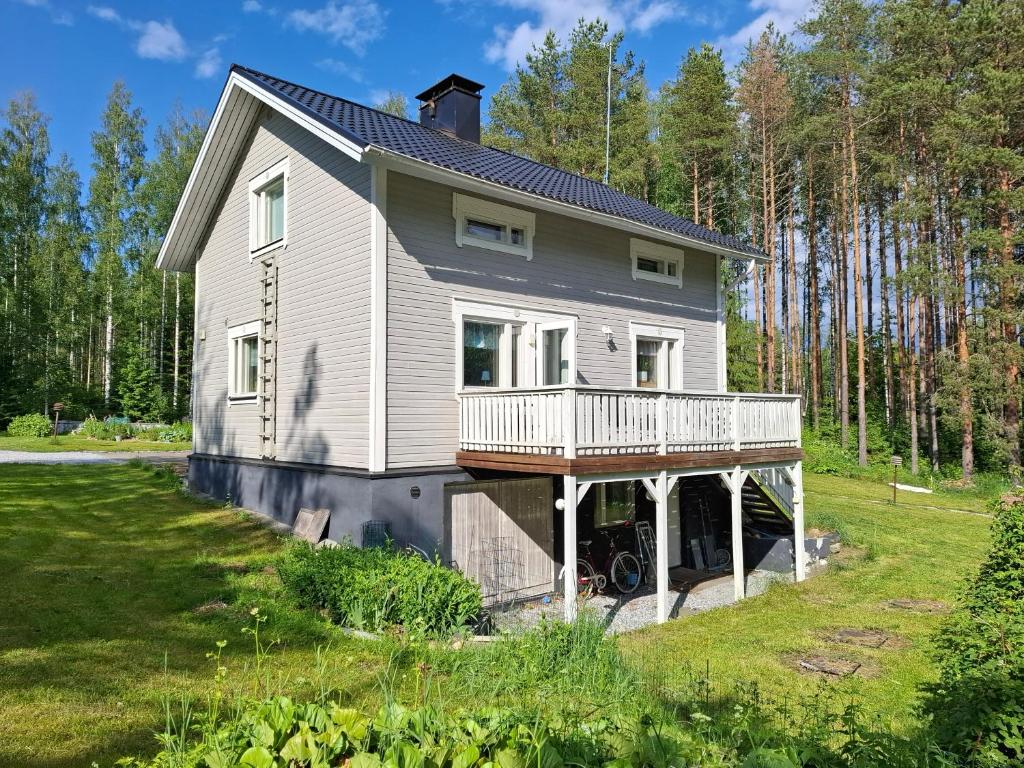 a house with a wrap around porch on a lawn at Ahopelto in Savonlinna