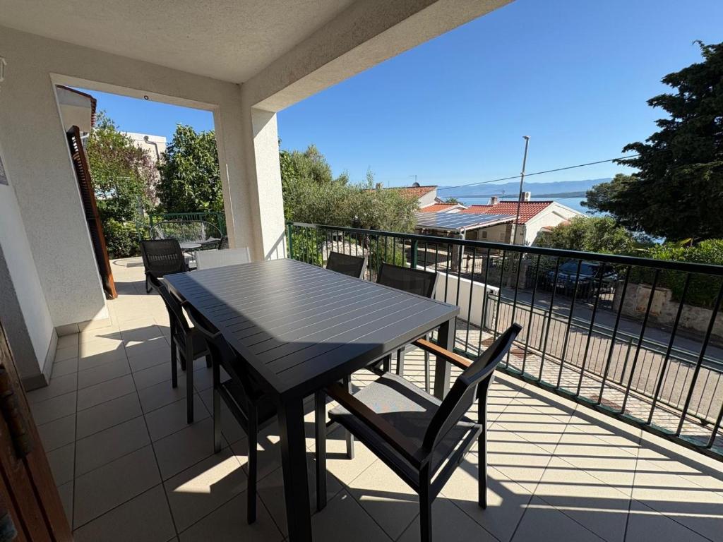 a black table and chairs on a balcony at Apartment Blue Bay in Malinska