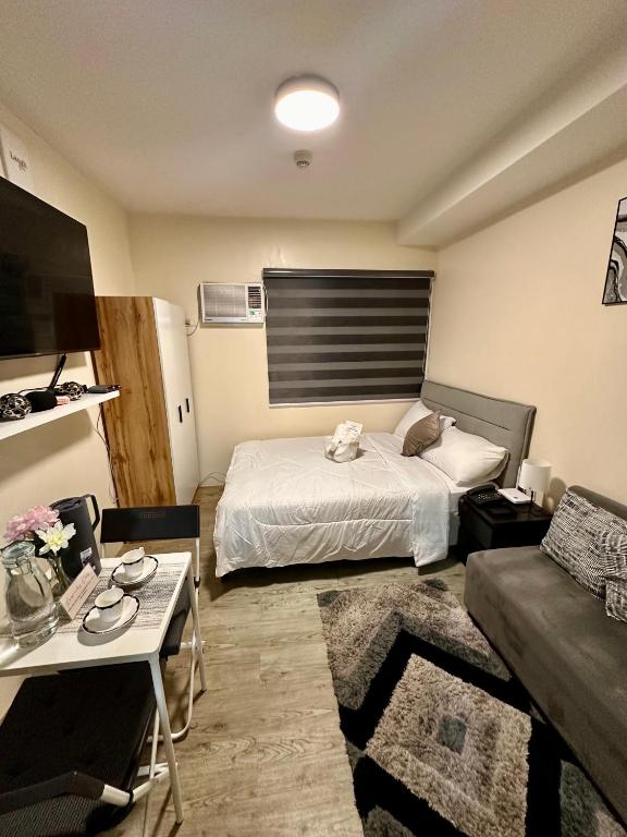 a small room with a bed and a couch at South Breeze Stay Near Nuvali, Enchanted kingdom, Tagaytay in Silang