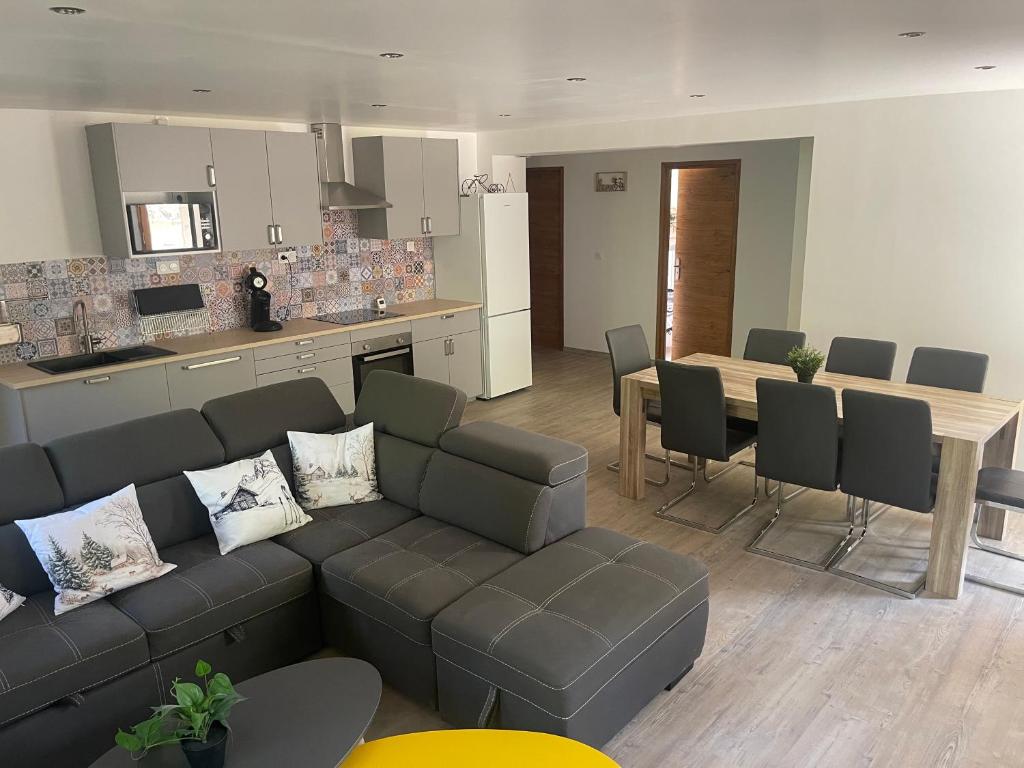 a living room and kitchen with a couch and a table at L'improbable, Spa, Netflix, Wifi, 500 m du centre historique in Guillestre