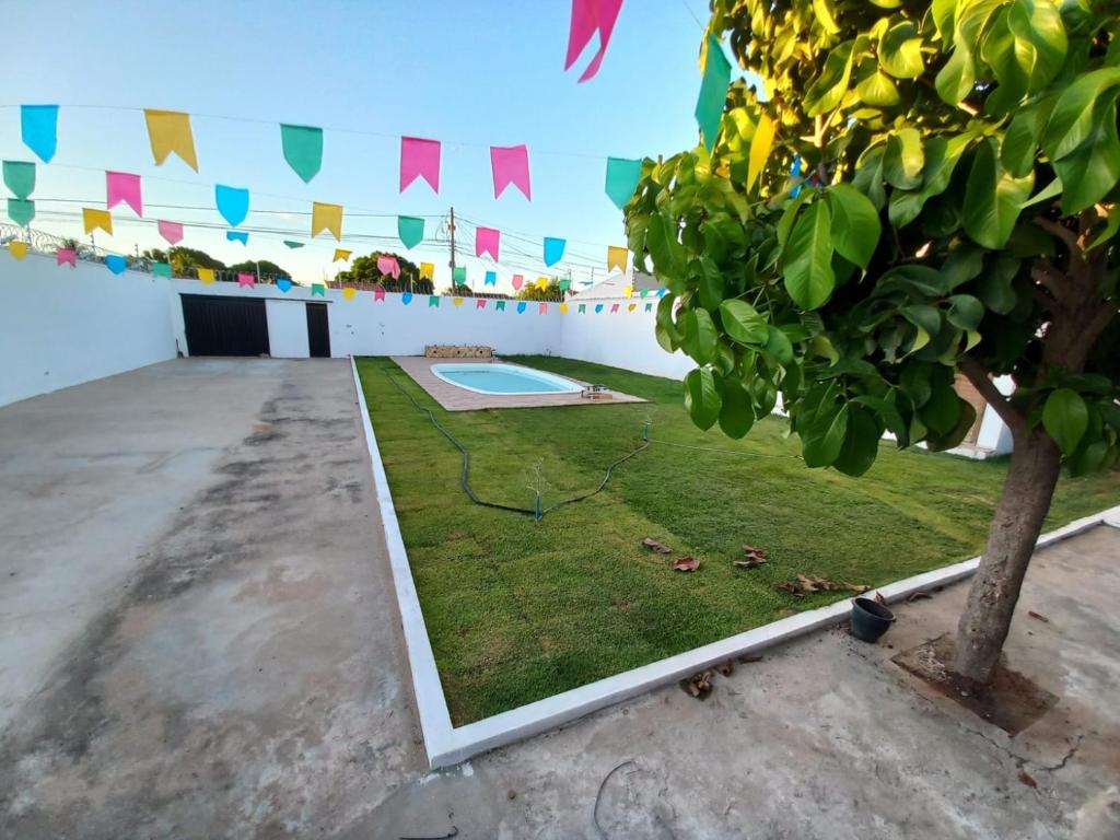 einen Innenhof mit einem Pool und einem Baum in der Unterkunft Chácara Corujá in Juazeiro do Norte