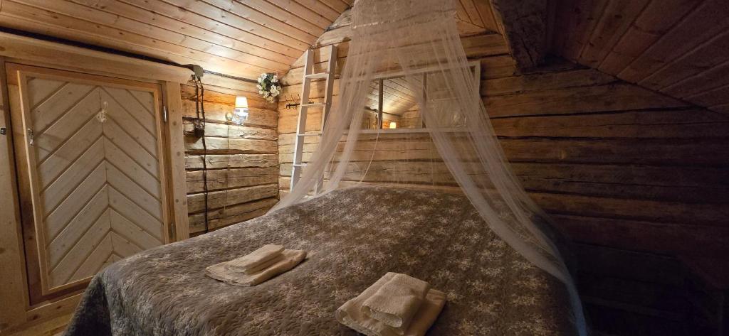a bedroom with a bed in a wooden cabin at Kulttuurikartano Pekan Pirtit in Haapavesi