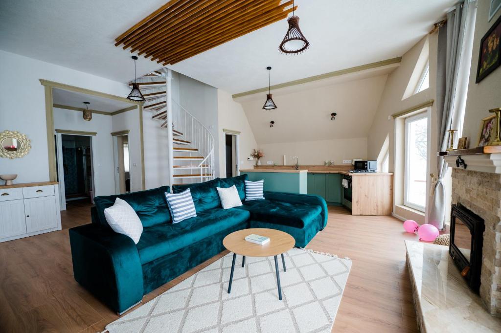 a living room with a green couch and a fireplace at Villa Stradivaryus in Sighetu Marmaţiei
