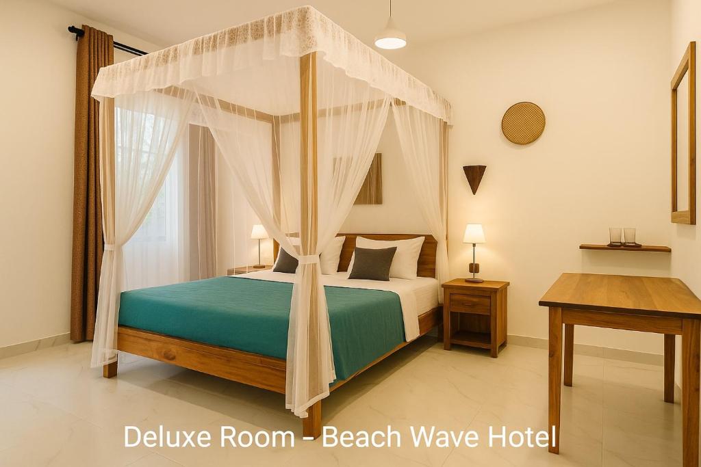 een slaapkamer met een hemelbed bij Beach Wave Hotel in Arugam Bay