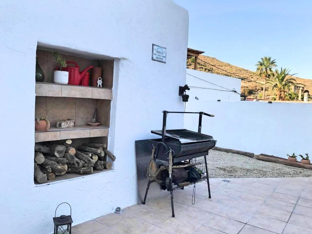 a grill on a patio next to a white wall at La Buganvilla del Pazo in Níjar