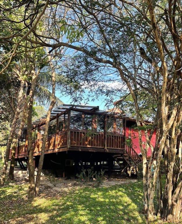 a house with a deck in the middle of trees at Chalé em Barreirinhas com Piscina e Cozinha - Refúgio da Vicky nos Lençóis Maranhenses in Barreirinhas
