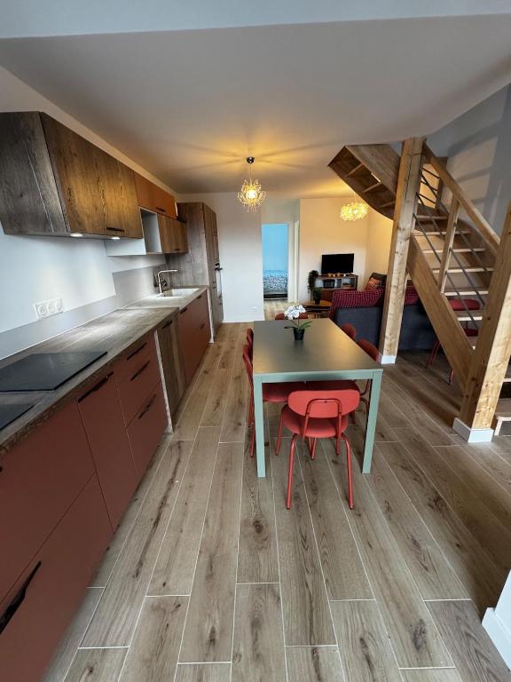 a kitchen with a table and a red stool at Maison pilotis 6 pers 50m mer in Les Moutiers