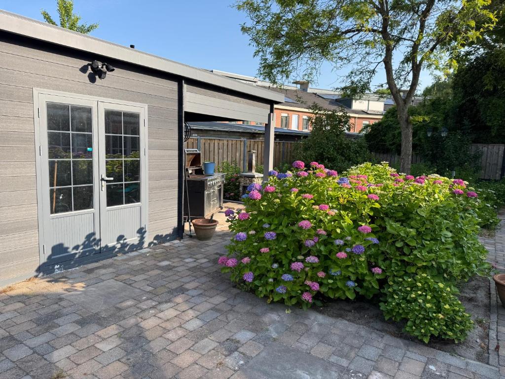 a house with a garage with a bunch of flowers at Maison Lelystad in Ons Belang