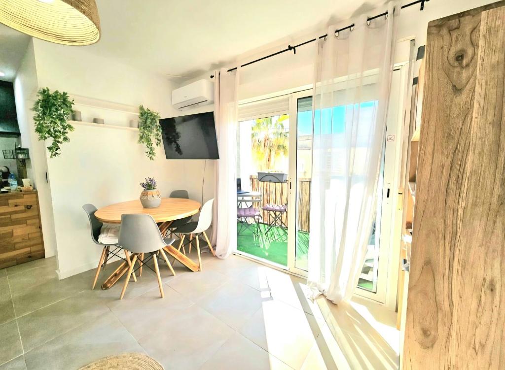 a dining room with a table and a balcony at Urban loft Valencia playa in Puebla de Farnals