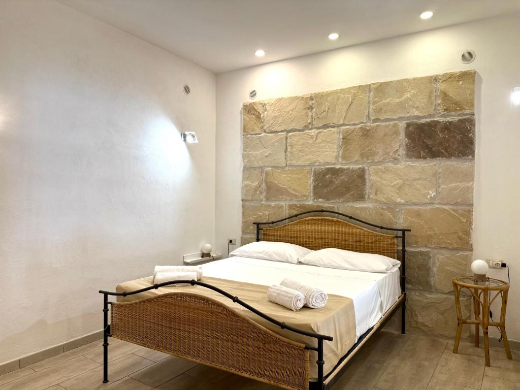 a bedroom with a bed with a stone wall at Al Castello - UN LETTO IDEALE in Gaeta