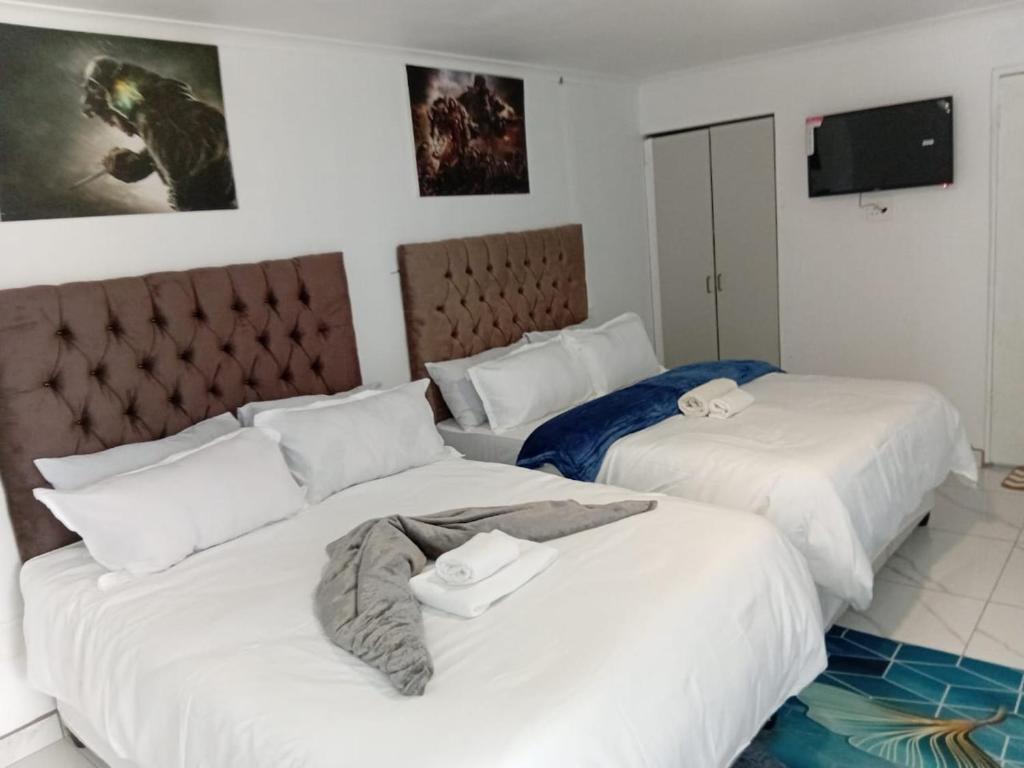 two beds in a hotel room with white sheets at PEACEFUL SLEEP lodge 1 in Goodwood