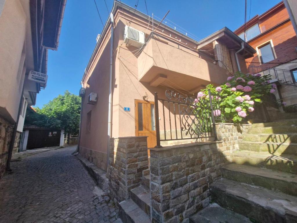 a building with a balcony and a door with flowers at Mihalkat Old Town in Sozopol