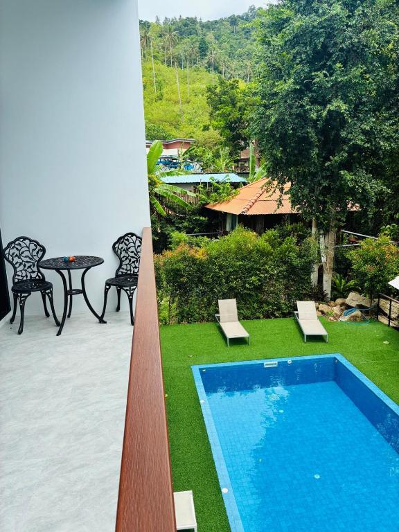 a swimming pool in a yard with a table and chairs at Hillside Haven-Luxury Room in Nathon Bay