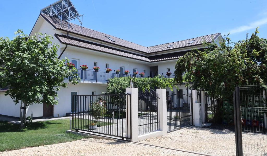 a white house with a gate and trees at Maison 25 in 2 Mai