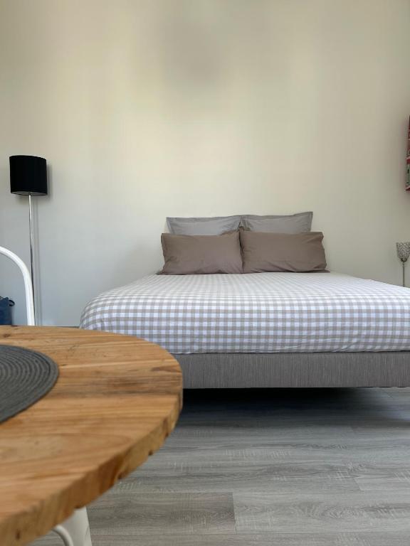 Ce lit se trouve dans un dortoir blanc doté d'une table en bois. dans l'établissement Studio élégant, central, pour 2 personnes, à Pornic