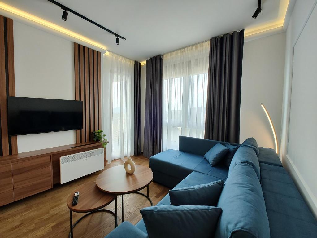 Una sala de estar con un sofá azul y un televisor en Omorika Lux, en Zlatibor