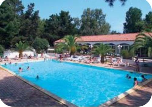 a large blue swimming pool with people in it at Mobil home 6 personnes à 400m de la mer in Argelès-sur-Mer