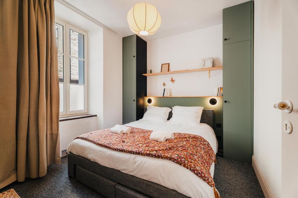 a bedroom with a bed with two towels on it at Le patio - Une cours intérieur au coeur du vieux Dinan in Dinan