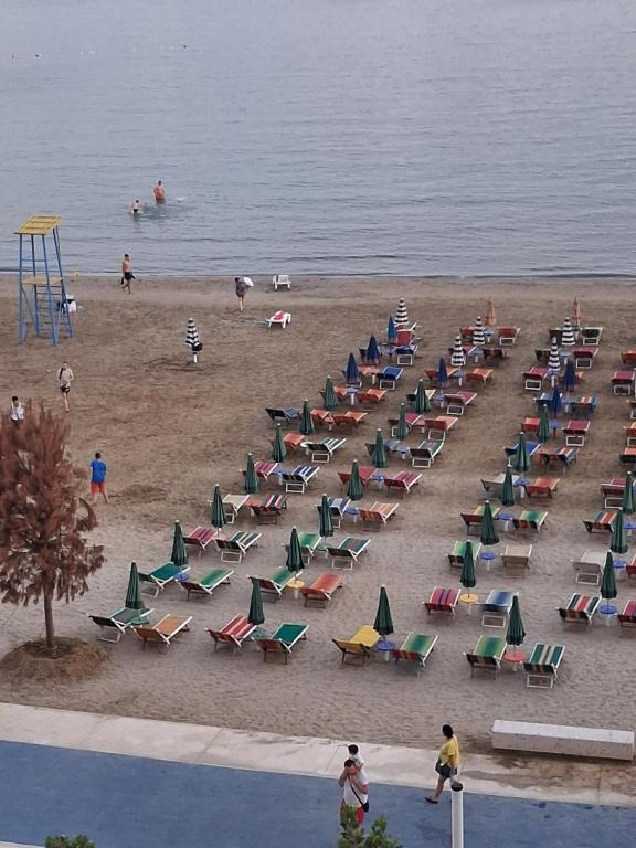 a beach with chairs and people in the water at Perla Blu Albania in Durrës