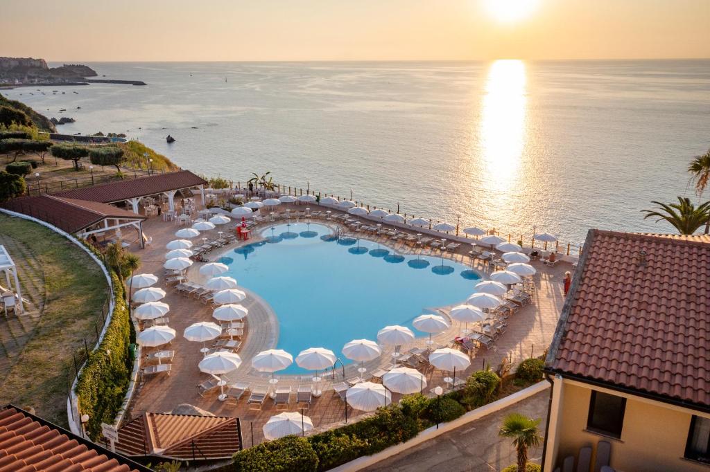 z widokiem na basen z parasolami i ocean w obiekcie Il Poggio Di Tropea w mieście Parghelia