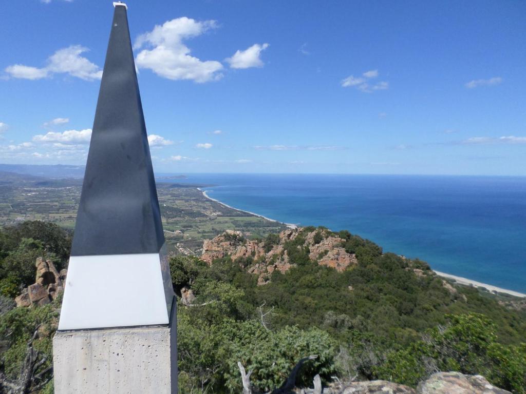 a monument on top of a mountain overlooking the ocean at B&B Sa Funtana in Cardedu