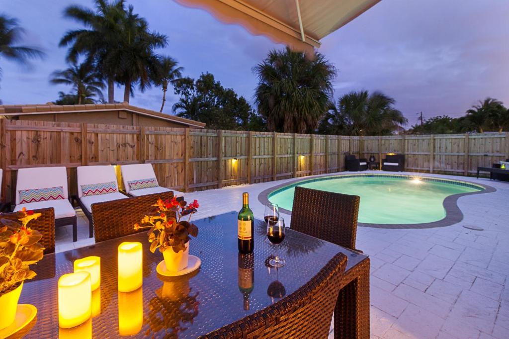 a patio with a table and a swimming pool at Beachway Per ankh (House of Life) in Pompano Beach